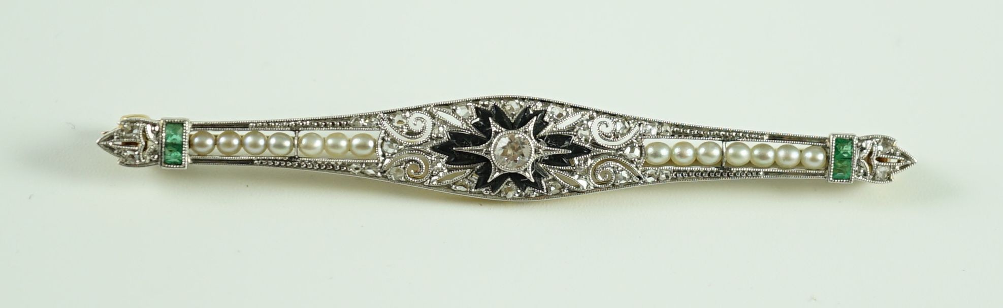 A 1920's gold and platinum, emerald, seed pearl, diamond and black onyx set bar brooch